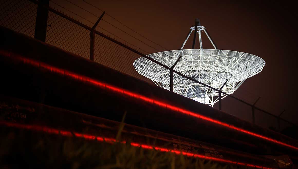Image of a a large satellite dish in a secure location.
